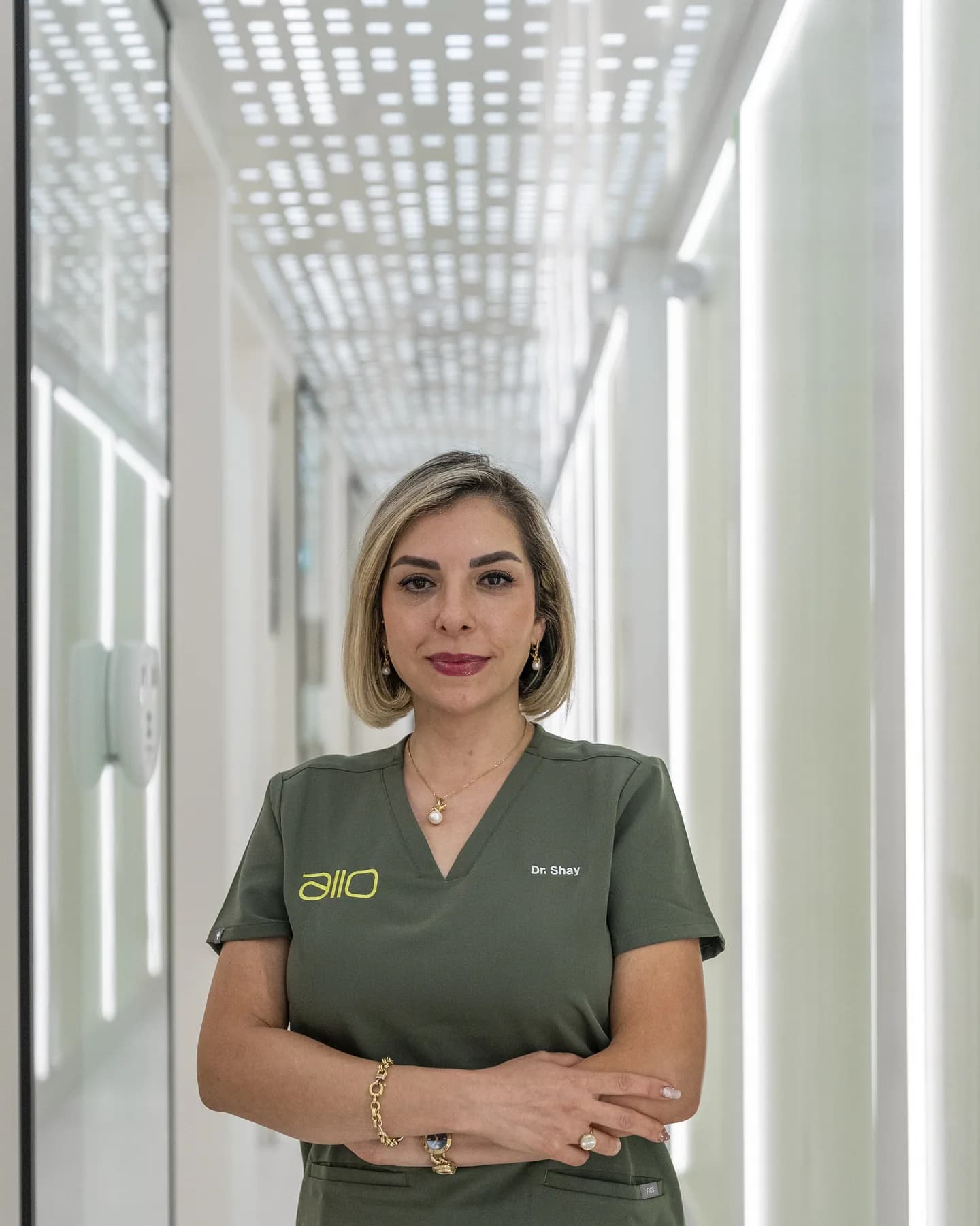 Dr. Shay Rahmatian, founding dentist, standing in the clinic corridor with her arms crossed
