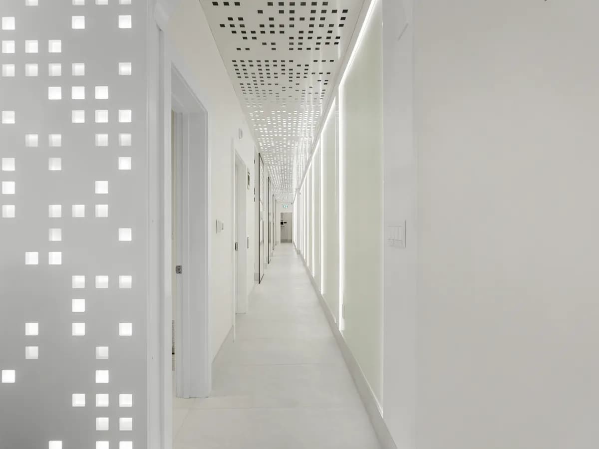 The corridor of treatment rooms, lit by the perforated wall