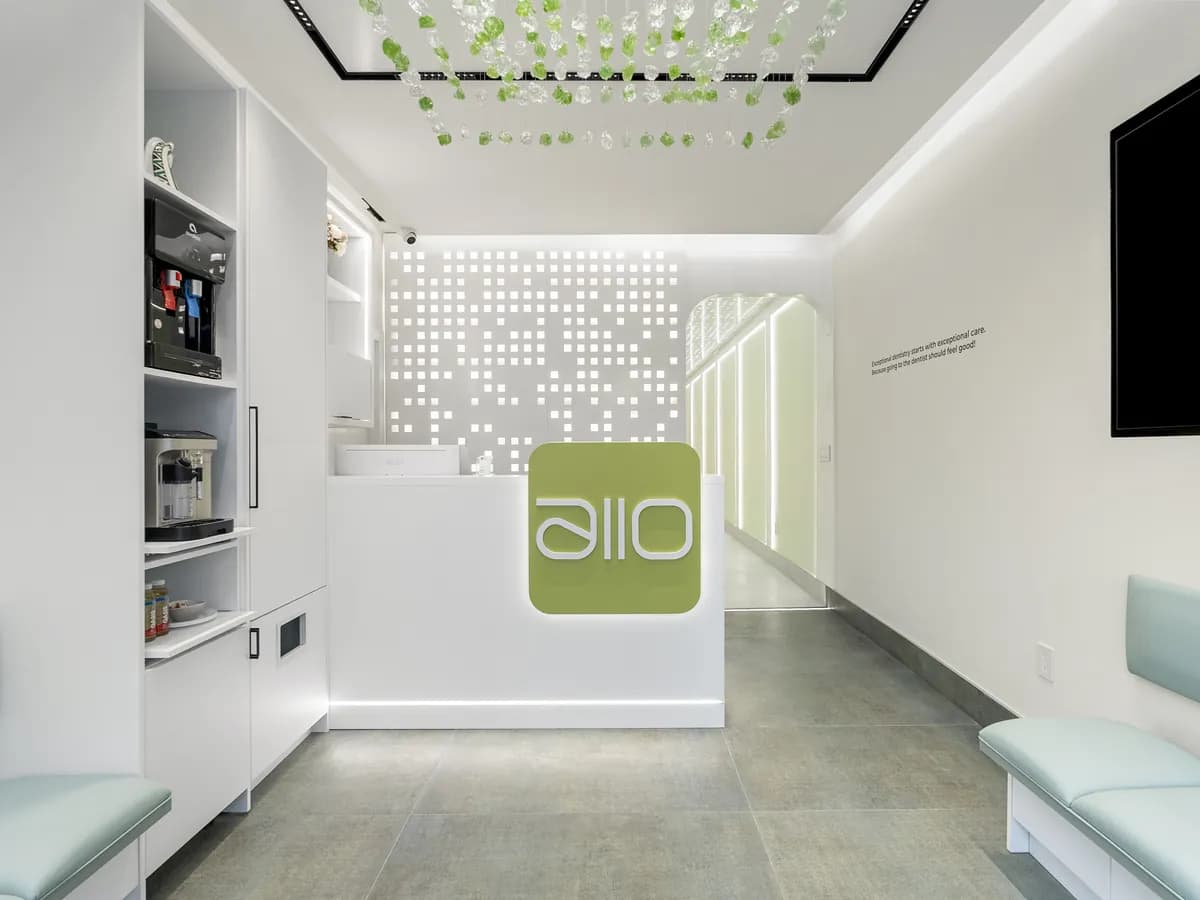 The reception desk with the allo logo, beneath the glass-leaf ceiling installation