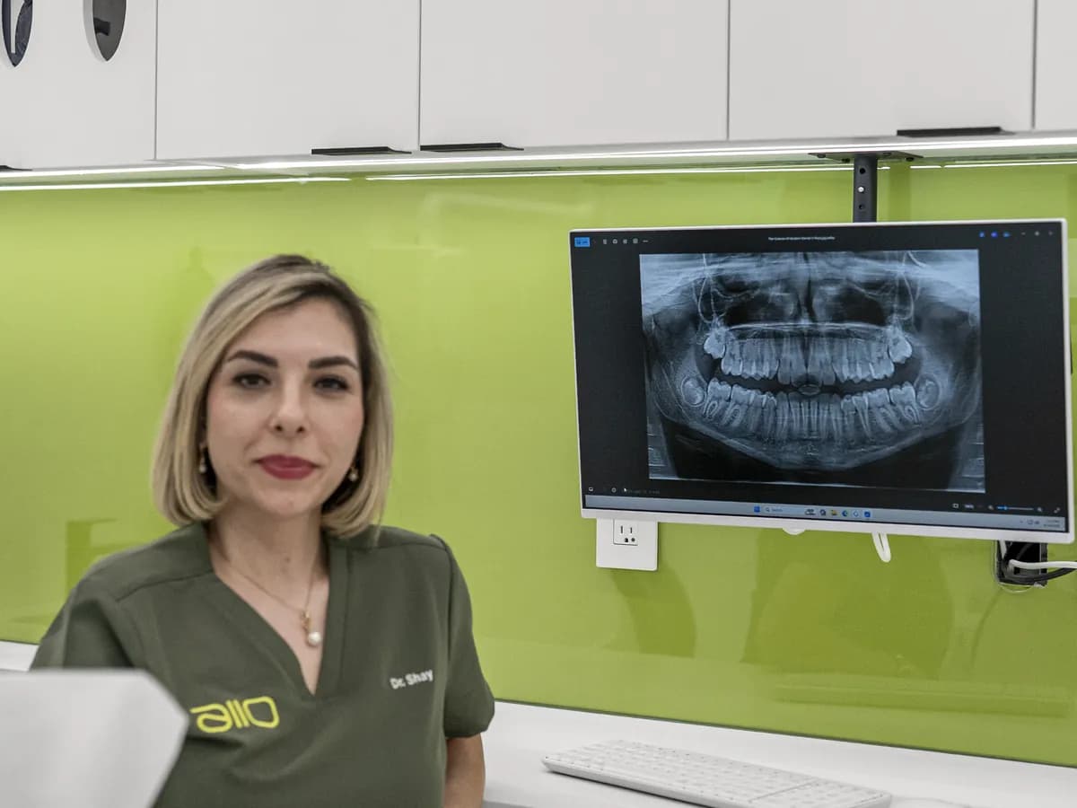 Dr. Shay Rahmatian at the chairside screen, a panoramic X-ray behind her
