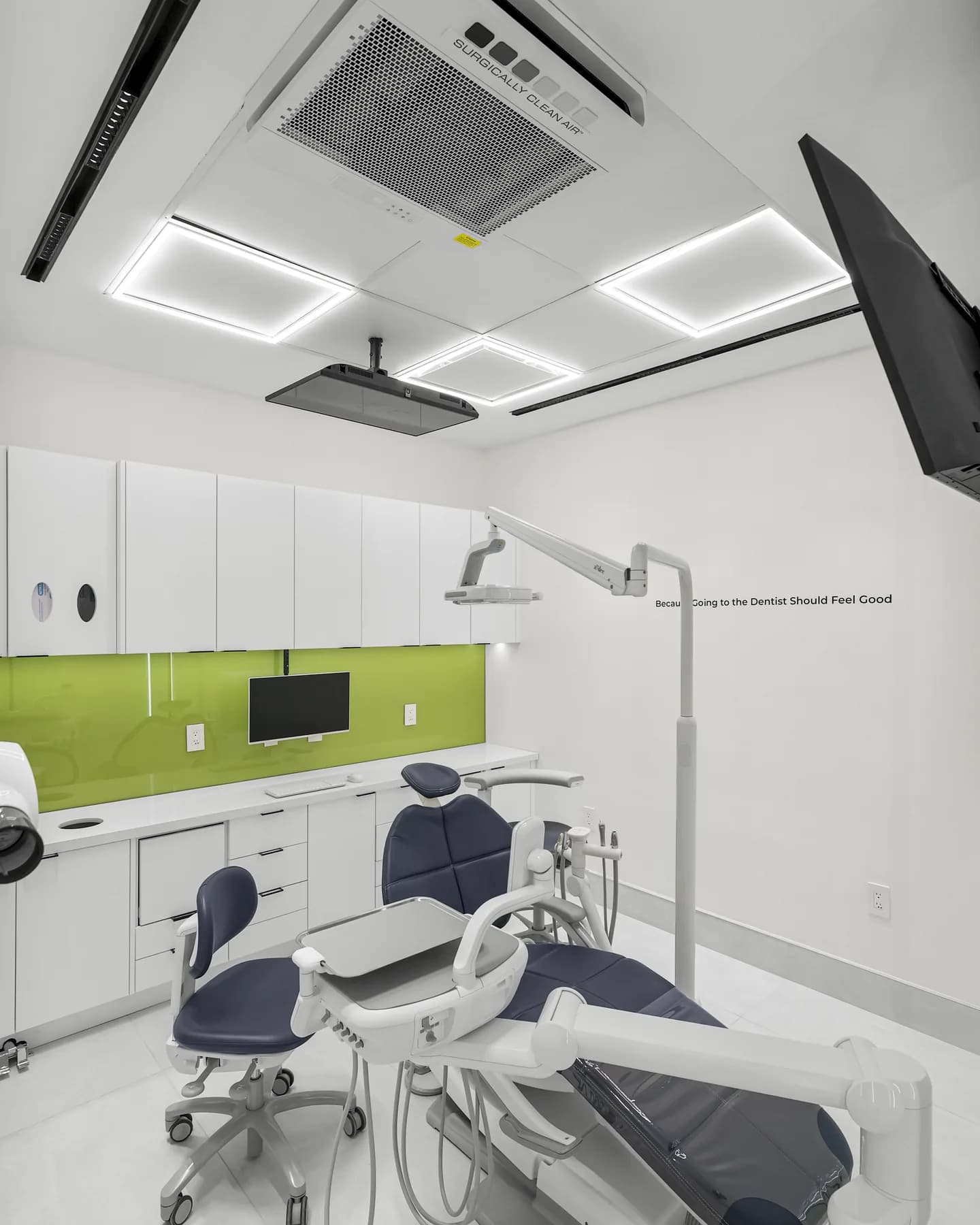 A treatment room at Allo Dental Clinic with an olive-green backsplash and chairside monitor