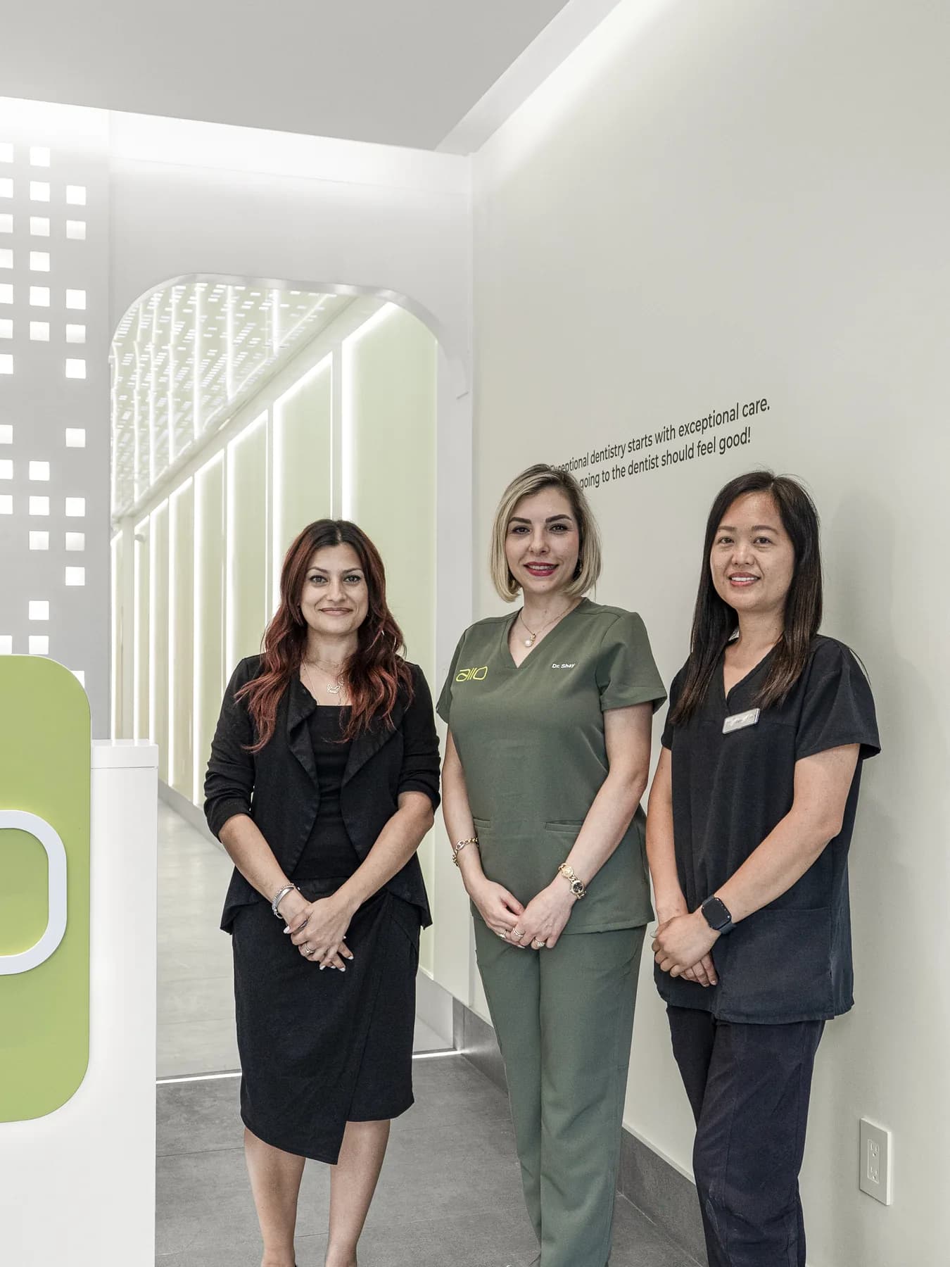 Three members of the Allo Dental team standing together at the clinic