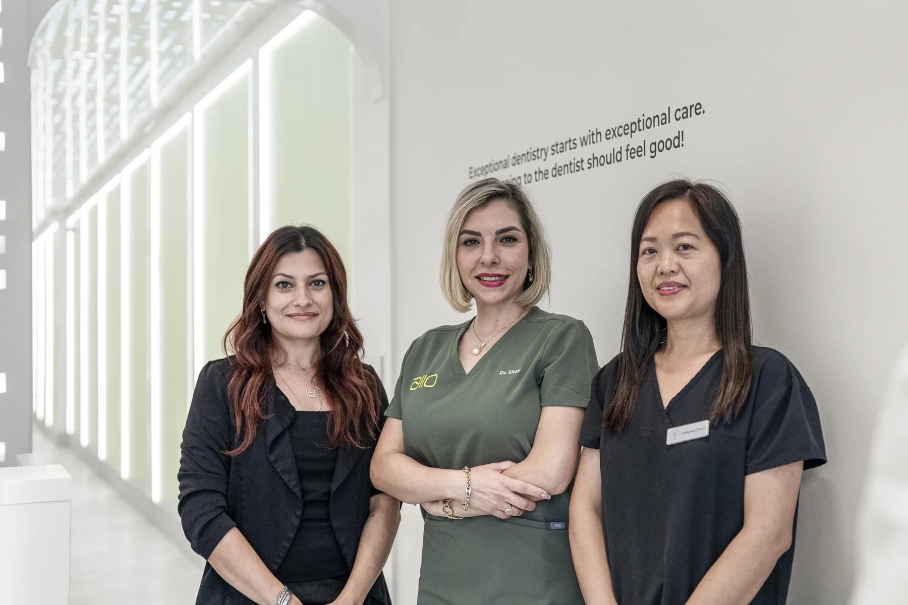 Three members of the Allo Dental team standing together at the clinic